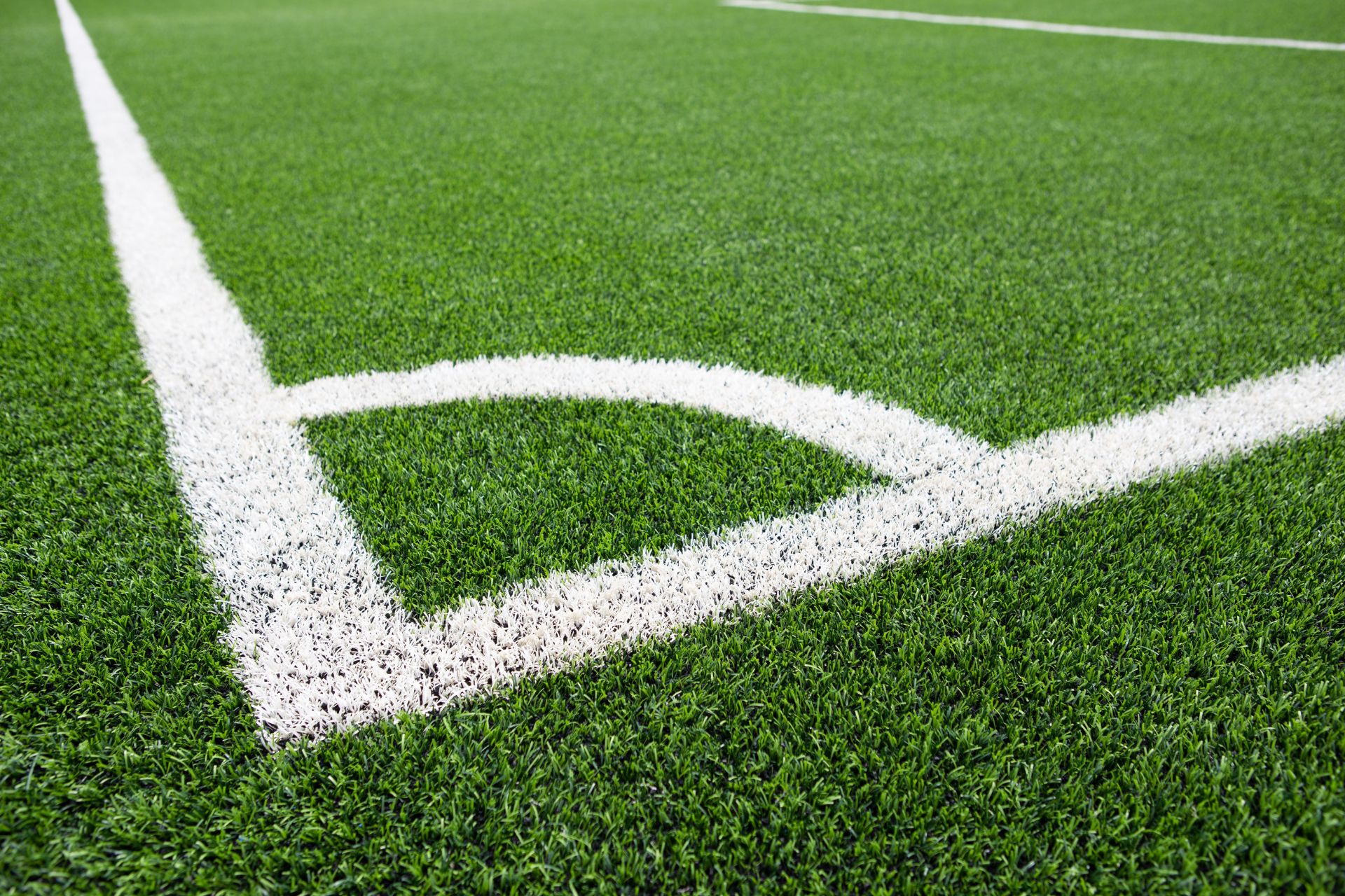 Artificial turf sports field with white soccer field markings and professional-grade synthetic grass.
